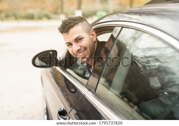 Young driver\
looks through the window of his\
car