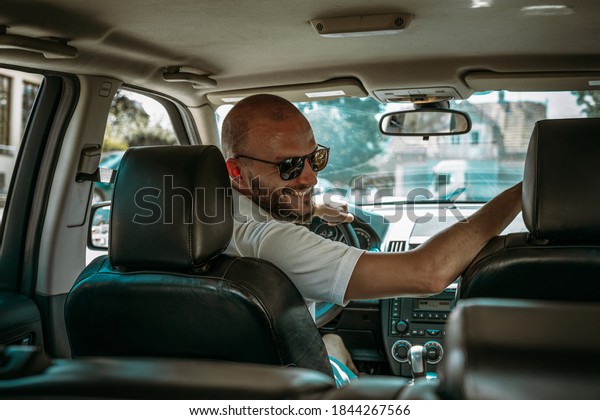 Young driver smiling and talking to other people in\
the car