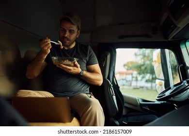 Young Driver Using Laptop On Lunch Break In Truck's Cabin.