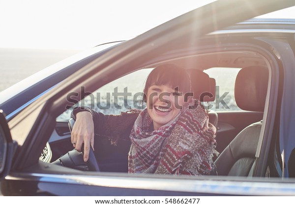 Young Driver woman in modern\
luxury car sitting in comfortable pose with happiness laugh\
emotion\
