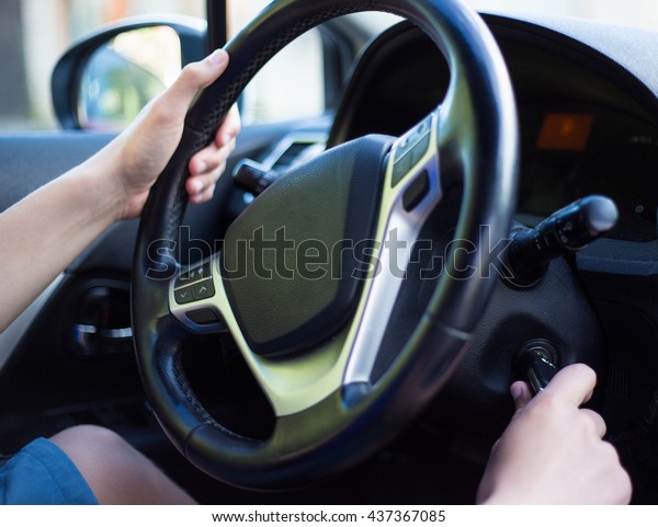 young\
driver\'s hand holding car key for starting the\
car