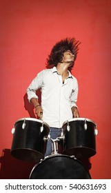 Young Drummer Head Banging Isolated On Red Background 