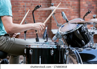 Young drummer playing at drums set