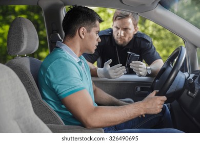 Young Drunk Driver And Angry Cop With Breathalyser