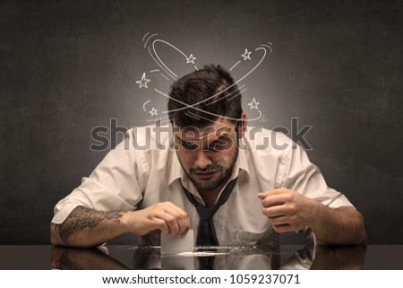 Young drunk man at his office with doodles around
