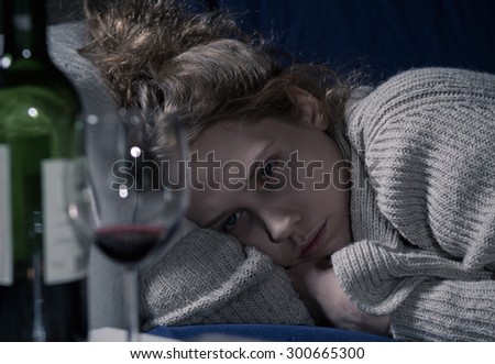 Similar – Image, Stock Photo A drunk woman is sitting at a table. Next to her is a bottle of alcohol and a glass. Bright yellow lights flicker in the background.