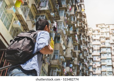 Young Dynamic Energetic Man Travels In Hong Kong Urban Location To See Real Living Of People In The Destination. Shooting With Unique Perspective With Interesting Background Of Overcrowded Mansion