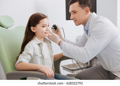 Young Ear Nose Throat Doctor Doing Hearing Exam Of Girl