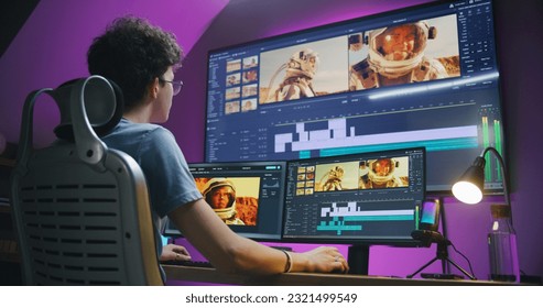 Young editor, video maker edits sound tracks for movie with astronauts, works at home office. Film footage and program interface with tools on computer and big digital screen. Post production concept. - Shutterstock ID 2321499549