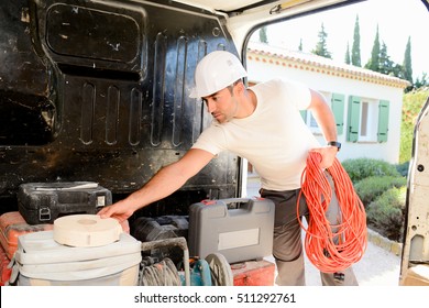 Young Electrician Artisan Taking Tools Out Of His Professional Truck Van