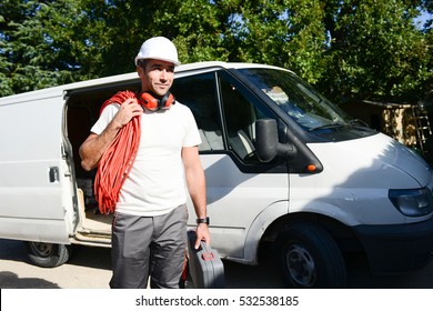 Young Electrician Artisan Taking Tools Out Of His Professional Truck Van