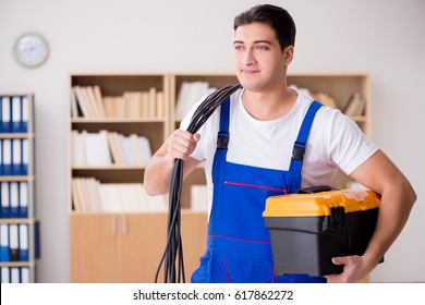 Young Electrician With Cable Working In Office