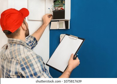 Young Electrician Installing Alarm System