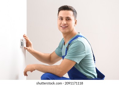 Young Electrician Repairing Socket In Room