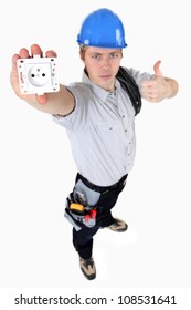 A Young Electrician Showing An Outlet.