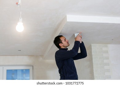 Young electrician working change a bulb at home - Shutterstock ID 1031772775