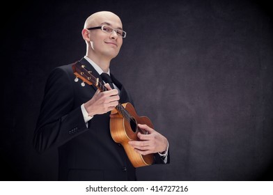 Young elegant alluring man with guitar and glasses black isolated