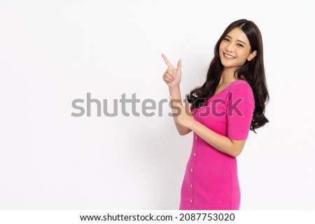 Young elegant beautiful Asian woman smiling and pointing to empty copy space isolated on white background
