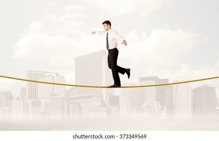 A Young Elegant Businessman Walking On Tight Golden Rope In Front Of City Buildings Landscape Background Concept