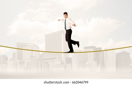 A Young Elegant Businessman Walking On Tight Golden Rope In Front Of City Buildings Landscape Background Concept