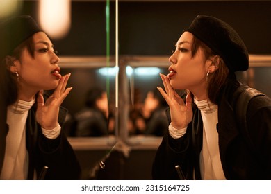 Young elegant girl doing her makeup with lipstick - Powered by Shutterstock