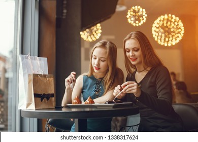 Young and elegant girls are sitting at the restaurant and eating dessert - Shutterstock ID 1338317624