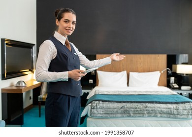 Young Elegant Hotel Manager Inviting You To One Of Rooms