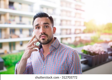 Young elegant man talking on the phone at balcony with a view - Shutterstock ID 312703772