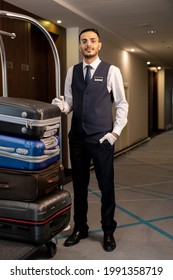 Young Elegant Porter Standing In Corridor Of Hotel