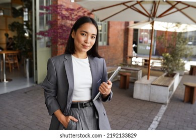 Young elegant professional leader Asian woman, female executive retail manager supervisor, small business owner wearing suit holding digital tablet standing outdoor looking at camera, portrait. - Shutterstock ID 2192133829