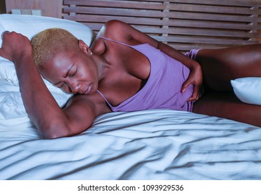 Young Elegant Sad And Depressed Black Afro American Woman Suffering Period Pain Or Stomach Ache And Abdominal Cramp Holding Her Tummy Feeling Sick And Unwell In Menstruation Cycle And Lifestyle