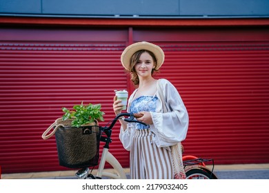 Young Elegant Woman With Holding Reusable Coffee Cup Over Red Background Outdoor. Concept Of Sustainability, Healthy Food And Modern Eco-friendly Lifestyle.