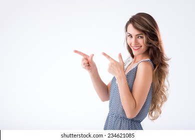 Young elegant woman pointing at white background