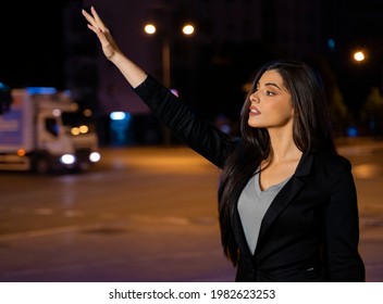 Young Elegant Woman Waving To Taxi Driver In The City At Night 