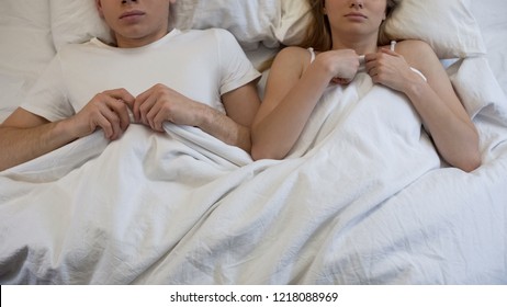 Young Embarrassed Couple Lying In Bed, Ashamed After First Intimate Experience