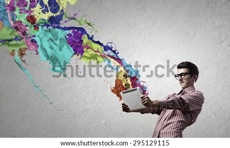 Young emotional businessman presenting tablet pc model