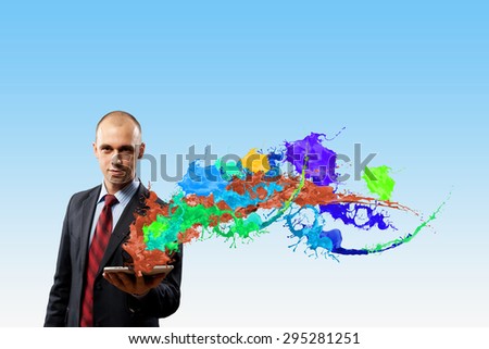 Young emotional businessman presenting tablet pc model