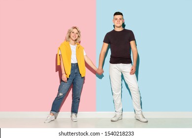 Young emotional man and woman in bright casual clothes posing on pink and blue background. Concept of human emotions, facial expession, relations, ad. Beautiful caucasian couple holding hands and - Shutterstock ID 1540218233