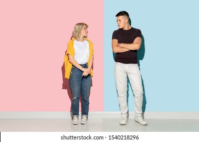 Young emotional man and woman in bright casual clothes posing on pink and blue background. Concept of human emotions, facial expession, relations, ad. Beautiful caucasian couple greeting and smiling. - Shutterstock ID 1540218296