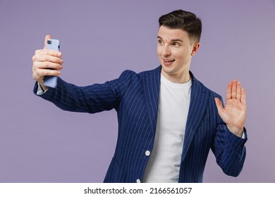 Young employee business man lawyer 20s wear formal blue suit white t-shirt work in office do selfie shot on mobile cell phone meet greet wave hand isolated on pastel purple background studio portrait. - Shutterstock ID 2166561057