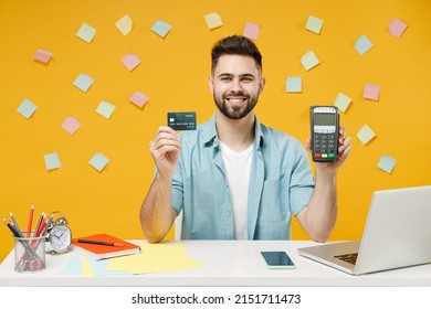 Young Employee Business Man In Shirt Sit Work At White Office Desk With Pc Laptop Hold Wireless Modern Bank Payment Terminal Process Acquire Credit Card Payments Isolated On Yellow Background Studio