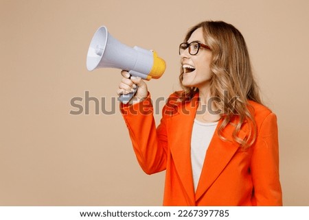 Young employee business woman corporate lawyer wear classic formal orange suit glasses work in office hold scream aside megaphone announces discounts sale Hurry up isolated on plain beige background