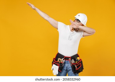 Young Employee Handyman Man In Protective Helmet Hardhat Do Dab Hip Hop Dance Hands Move Gesture Isolated On Yellow Background. Instruments Accessories Renovation Apartment Room. Repair Home Concept