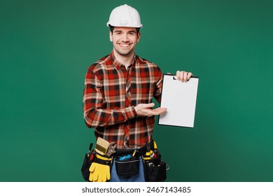 Young employee laborer man wear red shirt hardhat hat work show blank screen clipboard with paper documents isolated on plain green background. Instruments for renovation apartment Repair home concept - Powered by Shutterstock