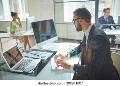 Young employee looking at computer monitor during working day in office - Shutterstock ID 309941807