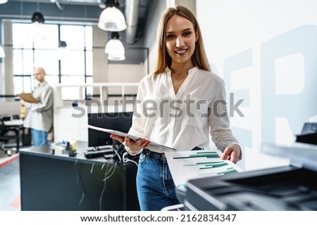 Young employee using modern printer in office [[stock_photo]] © 