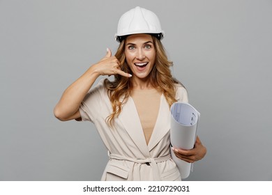 Young Employee White Woman Wear Pastel Clothes Hardhat Hold Blueprints Doing Phone Gesture Like Says Call Me Back Isolated On Plain Light Grey Background Studio. People Work On Architecture Project