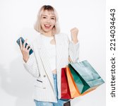 Young energetic Asian woman holding blank use smartphone searching shop retail with colorful shopping bags on white background. Online shoping futuristic concept.