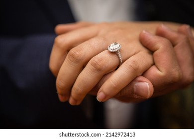 Young engaged couple, hands together, man and woman hands together, engagement diamond ring with big diamond on woman's finger, dark background
 - Shutterstock ID 2142972413