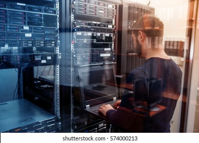young it engeneer business man with thin modern aluminium laptop in network server room - Shutterstock ID 574000213